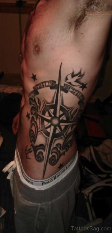 Black Ink Compass With Banner Tattoo On Man Left Side Rib