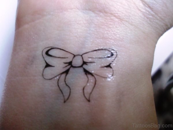Black Outline Bow Tattoo On Wrist