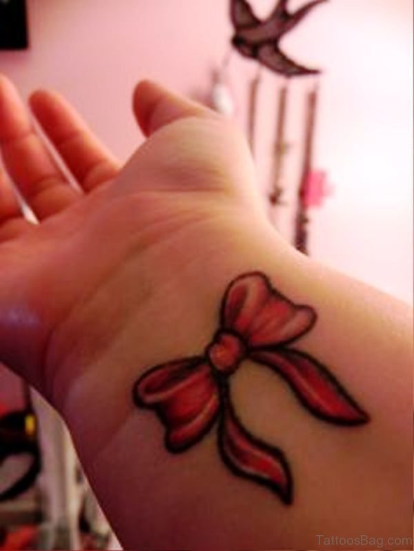 Delightful Red Bow Tattoo On Wrist
