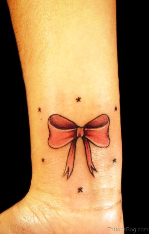 Red Ink Bow Tattoo On Wrist