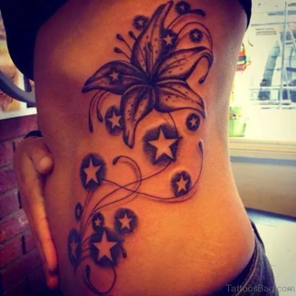 Star And Lily Flower Tattoo On Rib