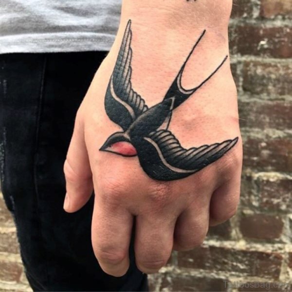Black And Red Ink Traditional Flying Swallow Bird Tattoo