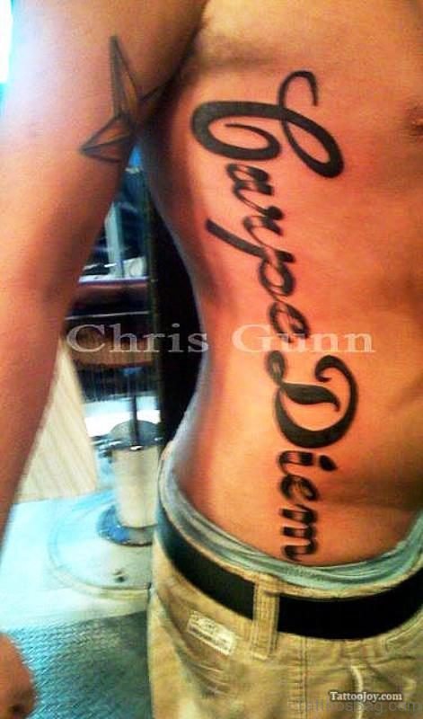 Black Inked Carpe Diem Tattoo On Rib